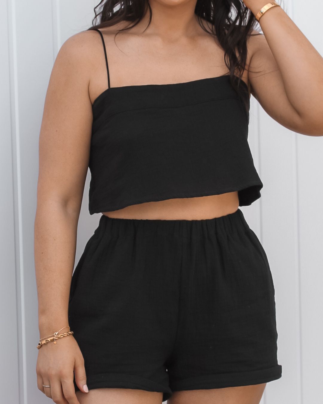Lightweight black cotton vacation shorts designed for resortwear and summer travel outfits.