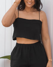 Breathable black cotton summer crop top with spaghetti straps styled for resortwear and vacation outfits.